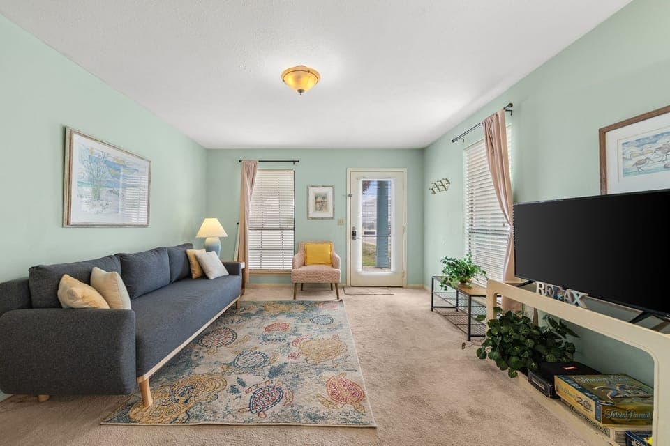 Sink into plush seating in your calming living room, where soft mint walls and natural light create the perfect retreat for relaxation.