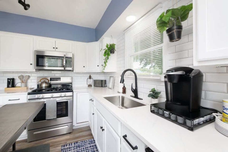 Modern kitchen w/ sleek counters, stainless appliances & functional layout