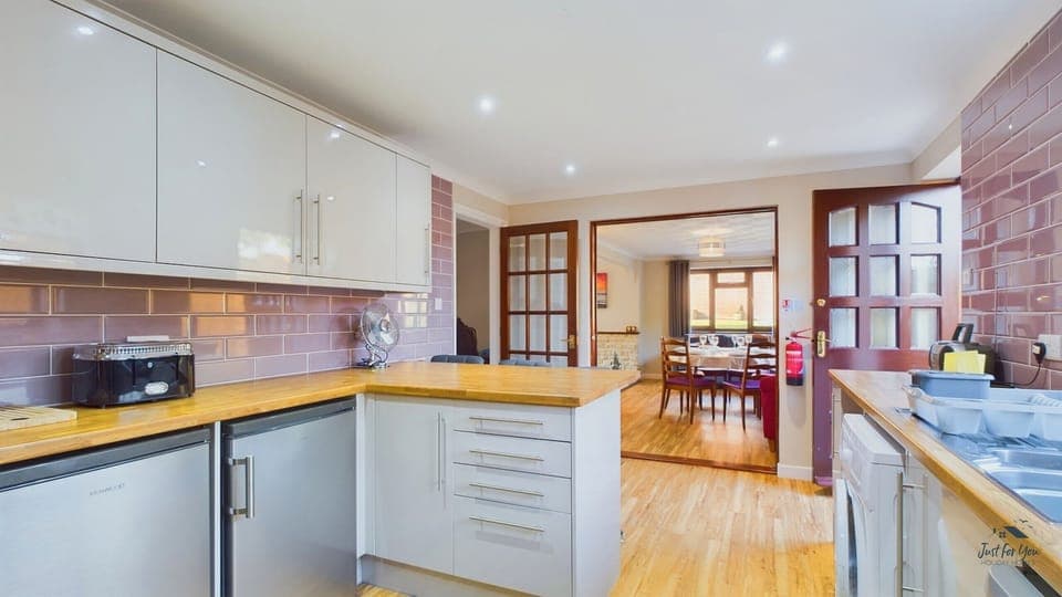 This spacious kitchen offers ample room for food prep, including an oven, hob, and dishwasher.