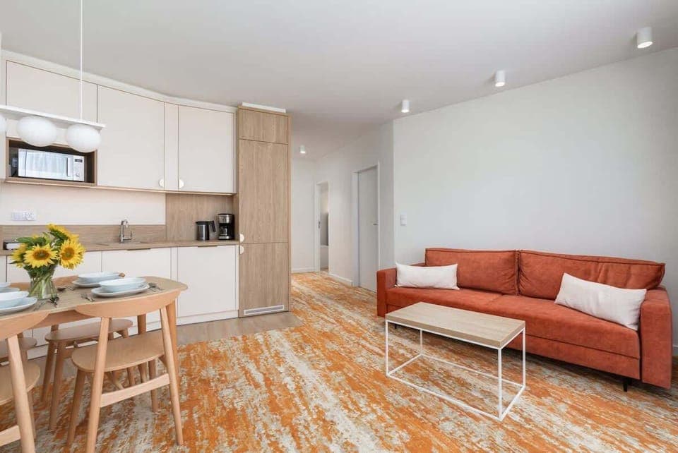 Living room with a comfortable sofa, TV, kitchenette and exit to the balcony