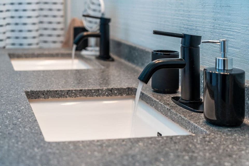 Sleek double-sink vanity with modern fixtures and essentials provided for your stay.