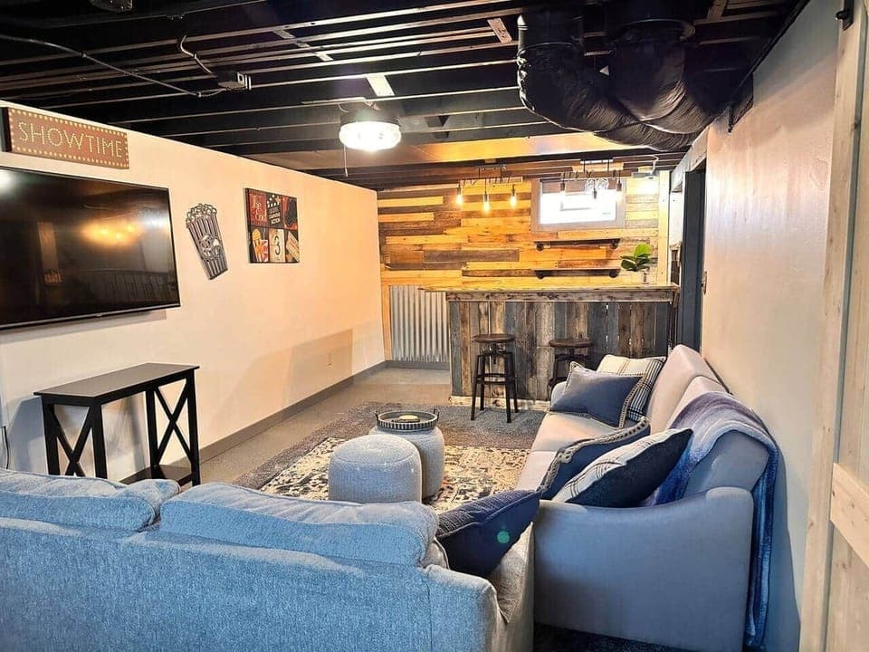 Finished basement with sofa's and bar area with TV and game table