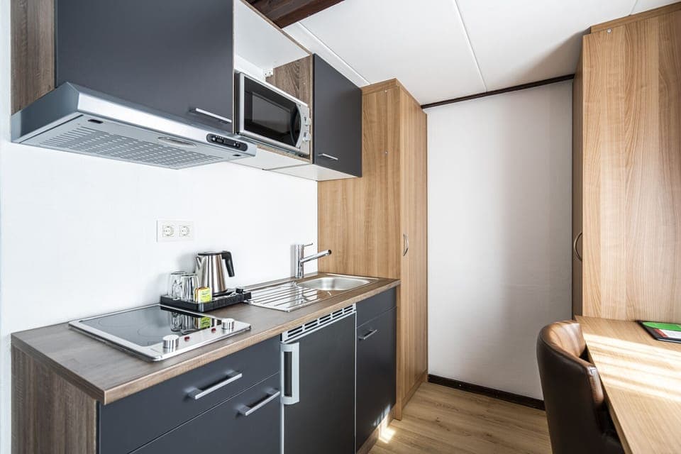 Studio | Desk, laptop workspace, blackout drapes, iron/ironing board