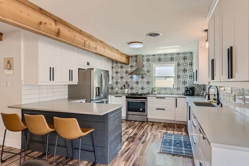 Spacious kitchen with a large island and seating, ideal for enjoying morning coffee or group meal prep.