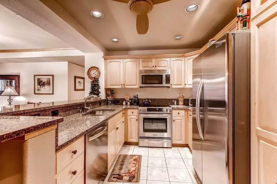 Prepare your meals in the fully-equipped kitchen featuring modern stainless steel appliances and granite countertops