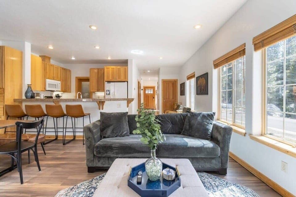 The open living room/dining area/kitchen is a space filled with natural light, an ideal space for socializing or relaxing with your group.