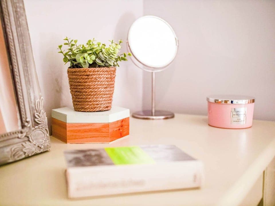 A bedside table with a small lamp, a plant, and decorative items, adding charm and functionality.
