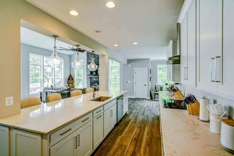 Large fully stocked kitchen with huge island, new stainless steel appliances, and large pantry.