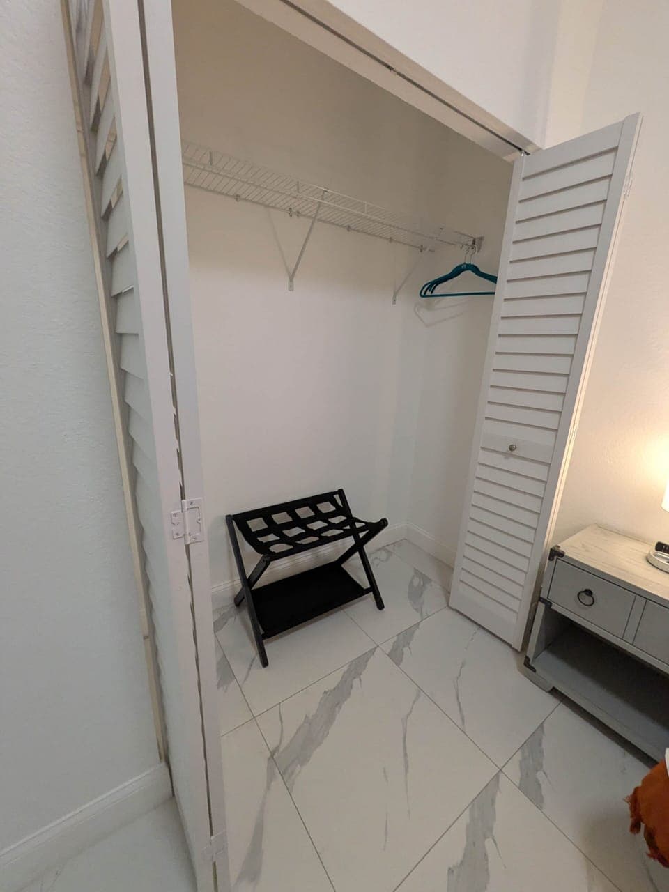 Bedroom 3: Closet, luggage rack & warm lighting.