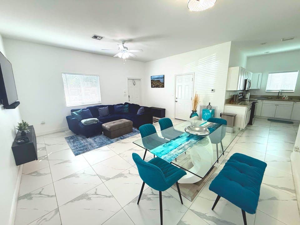 Spacious living room with seating for 6, king sleeper sofa, and smart TV in a bright, open layout.