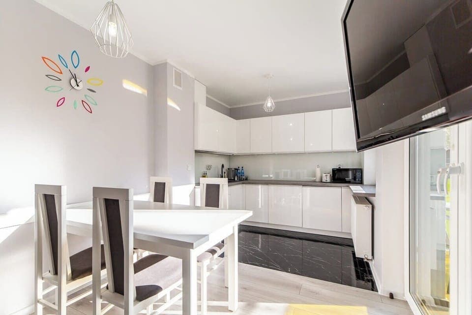A compact dining area with a white table and chairs, located near the kitchen for convenience.
