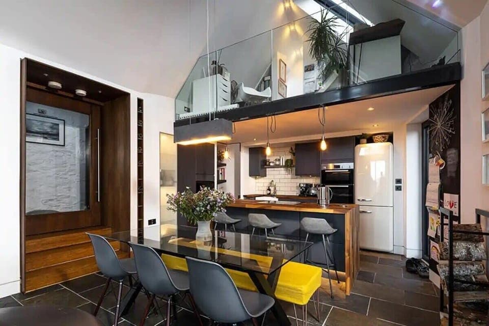 Social kitchen and living area with open balcony above