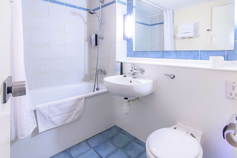 Separate tub and shower, hair dryer, towels, toilet paper