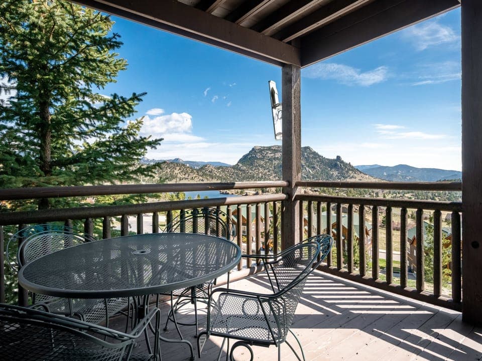 Powell Peak 104 - a SkyRun RMNP Property - Powell Peak 104 - Patio seating for four guests on the condo's deck, surrounded by beautiful mountain views.