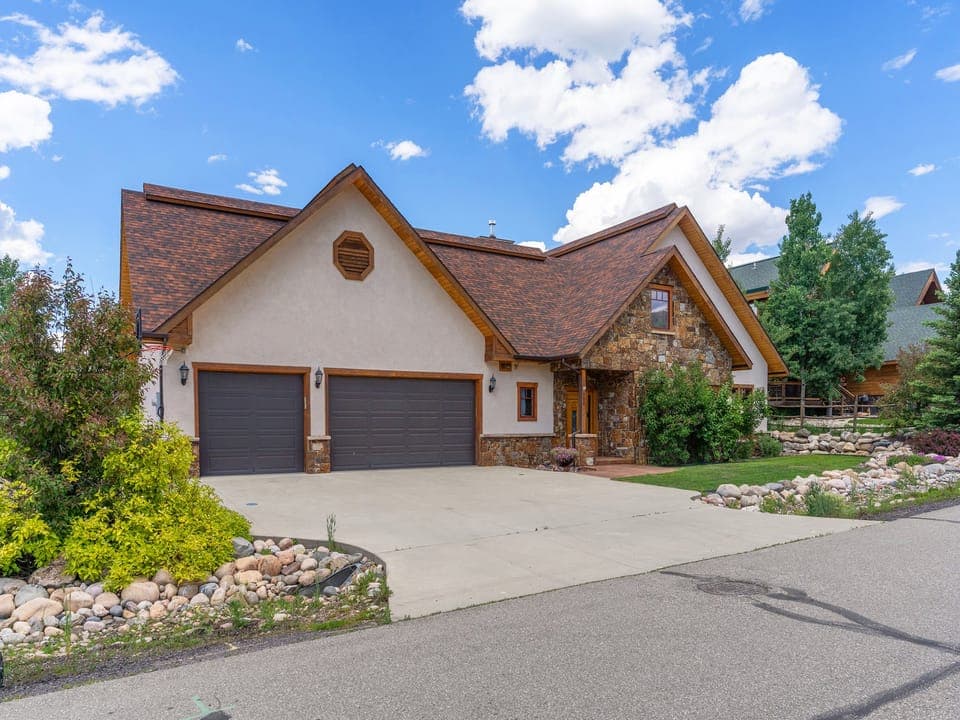 Cherry Drive, your home away from home in beautiful Steamboat Springs! - Large home, driveway, green lawn, blue sky.