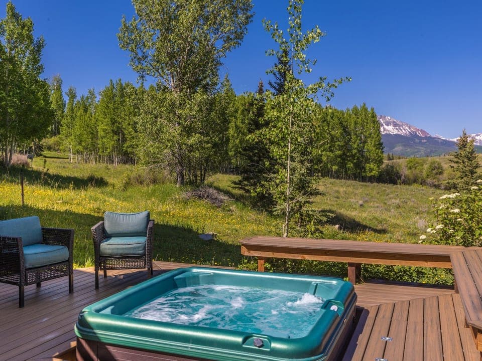 This home features stunning views with a multi-level deck featuring outdoor seating/dining, hot tub, gas grill and a huge open backyard.