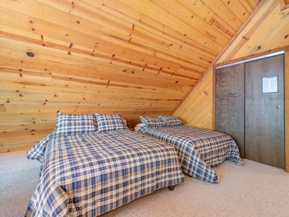 The upstairs bonus room features two full beds, comfortably accommodating up to four guests for a cozy night's sleep.