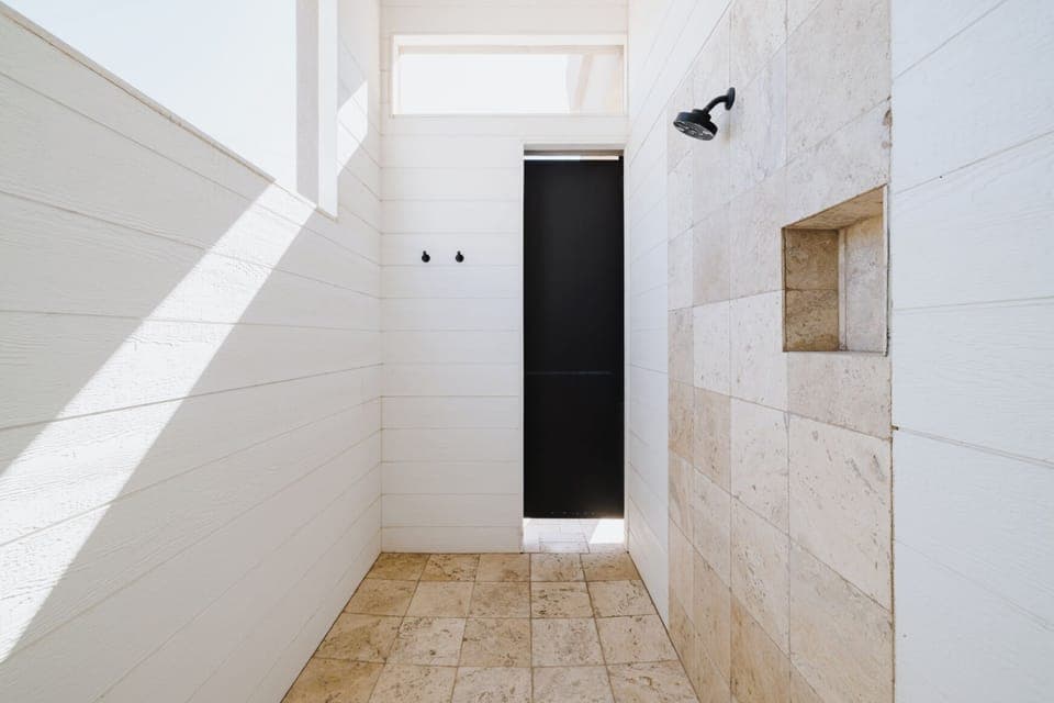 Primary Bathroom with Two Sinks, Water Closet, Bathtub, and Outdoor Shower