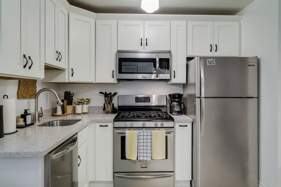 The kitchen features stainless steel appliances, a gas range, a dishwasher, a microwave, an electric kettle, a coffee maker, a blender, and more!