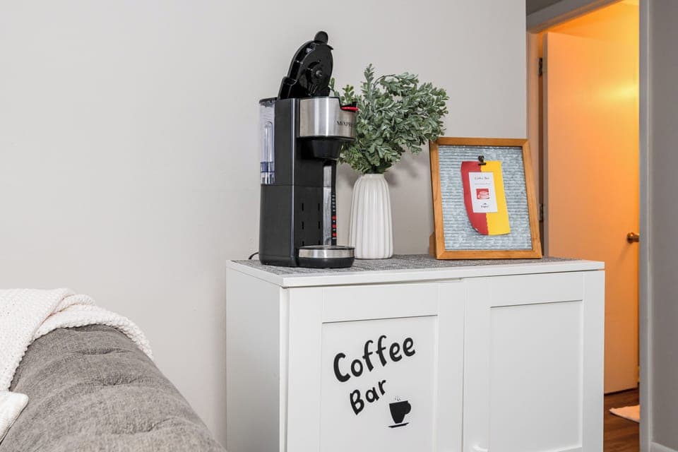Your private coffee bar includes a user-friendly single-serve machine, filtered water reservoir, and coffee supplies—set up in a cozy corner for added convenience during your stay.