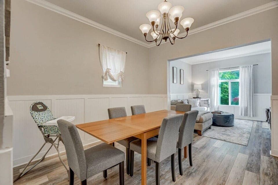 Beautiful Lighting Streaming Through the Expansive Window, Connecting the Dining Space with the Charming Living Room