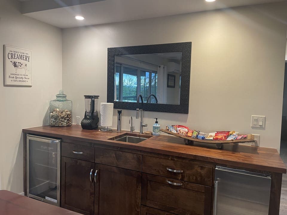 Adjacent to the dining, the bar area includes an ice maker and a wine fridge. 