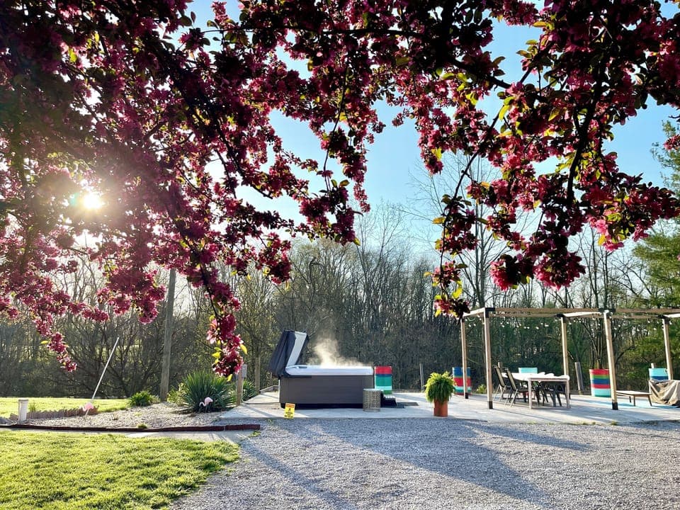 Patio features a hot tub, dining area, sun loungers (2), fire pit and gas grill.