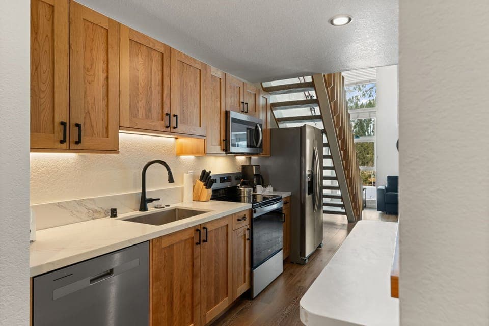 Your fully equipped kitchen features warm wood cabinetry, granite counters, and stainless steel appliances for memorable meal preparation.