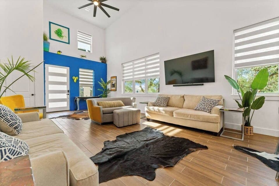 Large spacious living room, comfortable furniture,  vaulted ceilings, lot's of natural lighting, large windows with electric blinds, fun art & colorful accents, etc.  