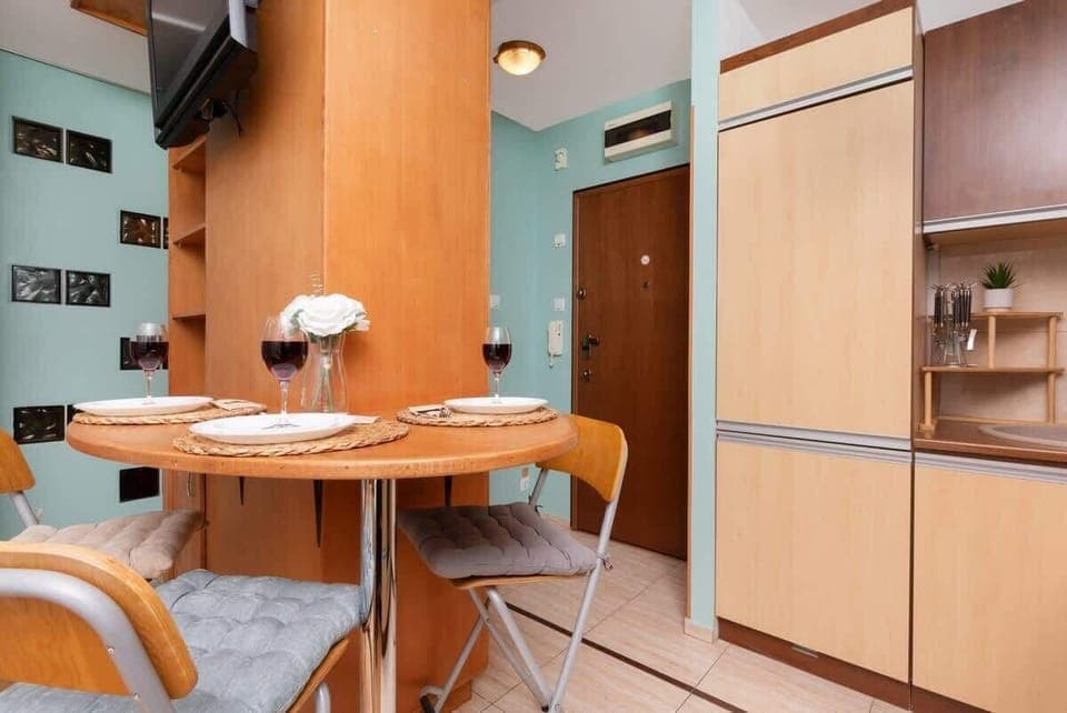Another perspective of the open-plan kitchen, emphasizing the warm wooden tones, mint-green accent walls, and ample cabinetry.

