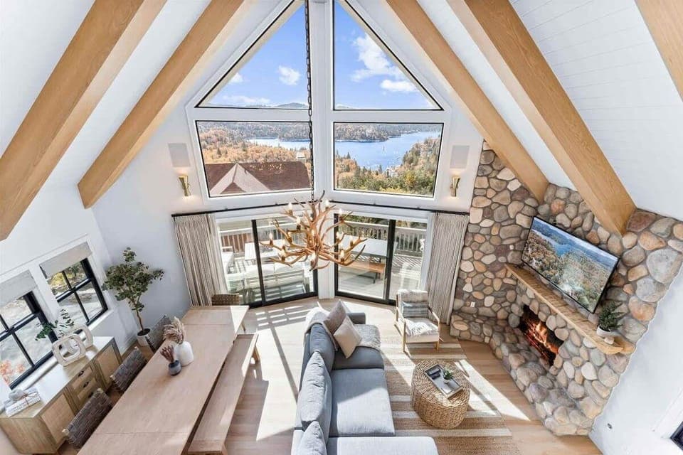 A bright open concept  living space with fireplace, smart  TV and views.