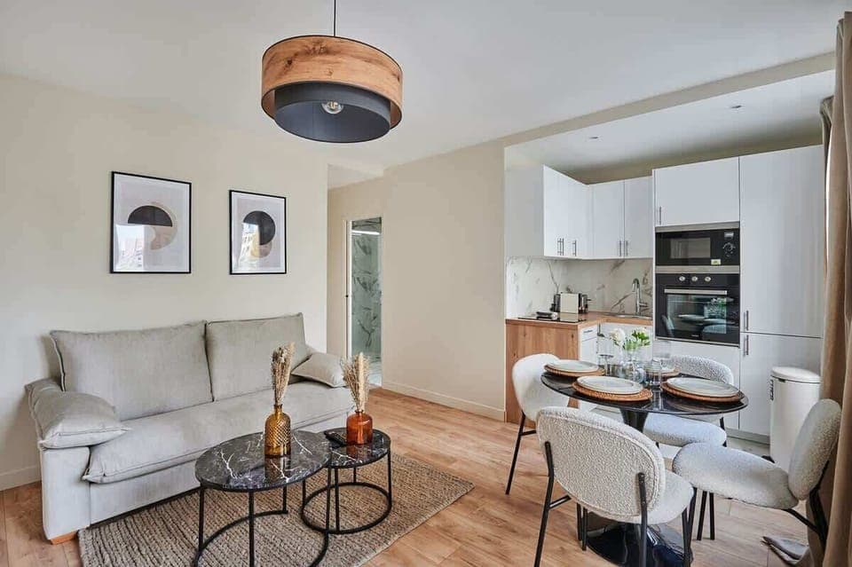 Salon avec canapé lit , cuisine américaine et coin repas