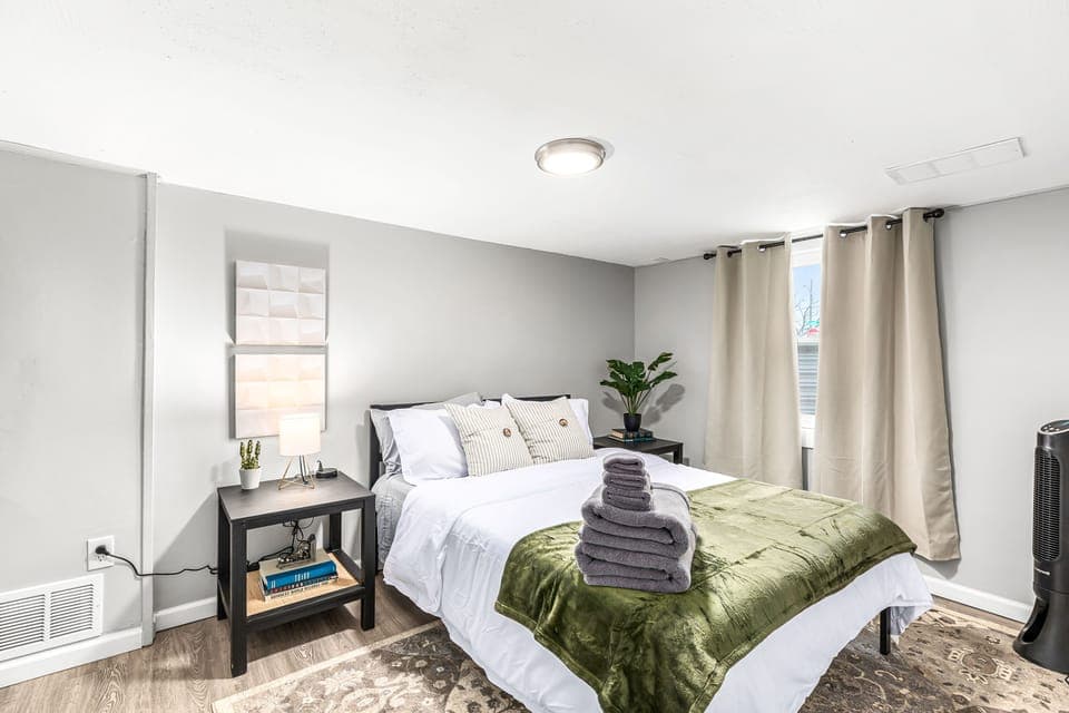 This cozy bedroom is decorated in warm neutral tones, with a plush bed and fluffy pillows.