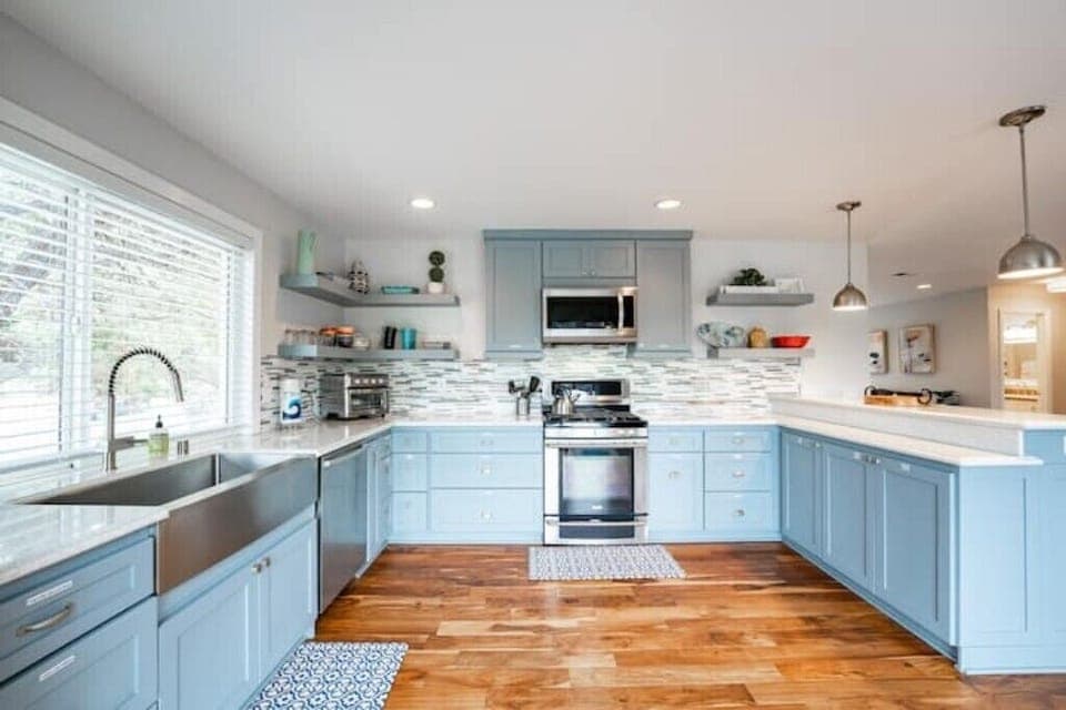 Fully equipped spacious chef kitchen with multiple prep areas. Opens into deck.