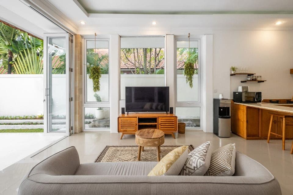 Spacious living area with natural light, TV, and direct access to the garden