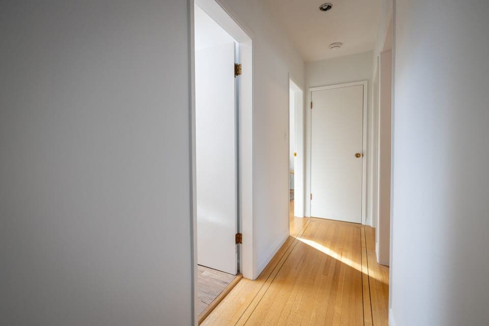 Hallway showcasing beautiful original lined hardwood flooring