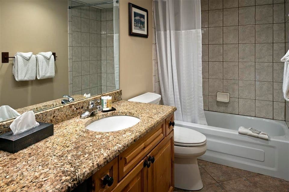 Freshen up in the modern bathroom with granite vanity and shower/tub combo.