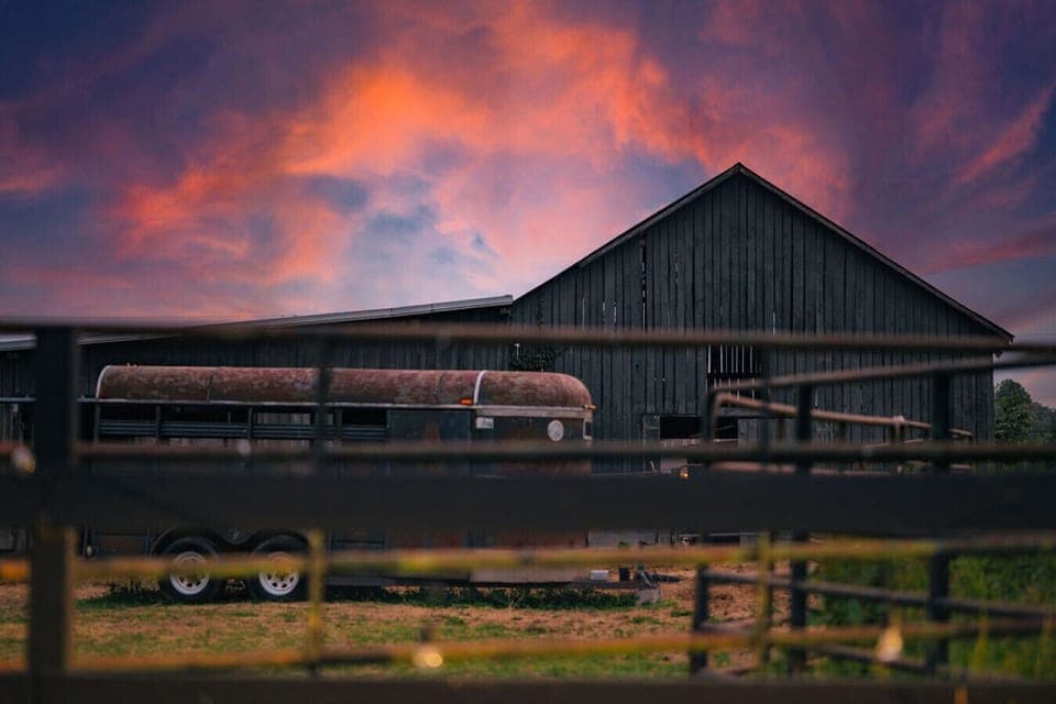 As the sun dips low, our barn is framed in fiery skies- a picture-perfect ending to a peaceful day in the country side.