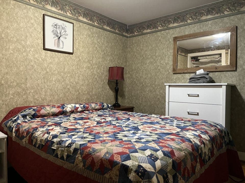 Indulge in a restful escape within this cozily designed bedroom, boasting a pleasant queen bed, a dedicated workspace with a desk, a dresser, and a generous closet. Experience the perfect blend of comfort and sophistication