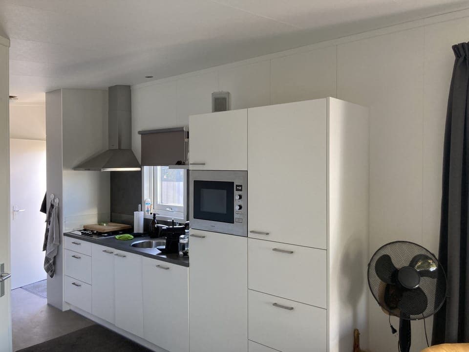 Kitchen with dishwasher, microwave and big refrigerator.