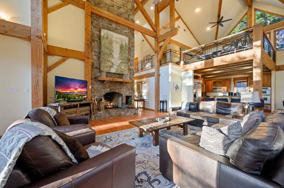 Where the aroma of home-cooked meals meets the cozy warmth of the fireplace in our cabin's open kitchen and living room.