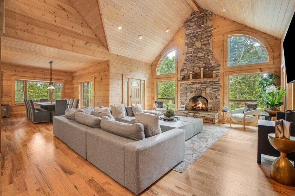 Unwind in this cozy living room with a warm stone fireplace and plush seating – perfect for family movie nights or quiet evenings in.