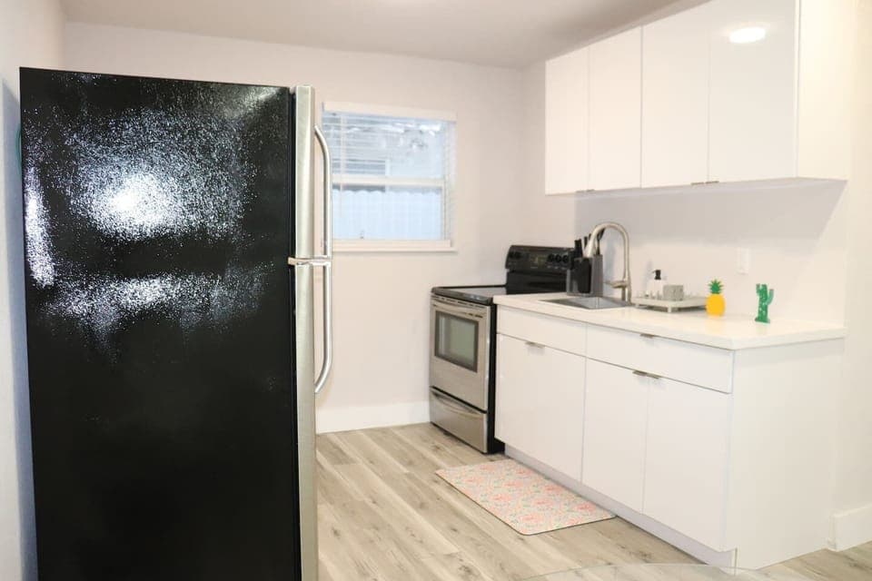 Bright kitchen featuring modern appliances and white cabinets.