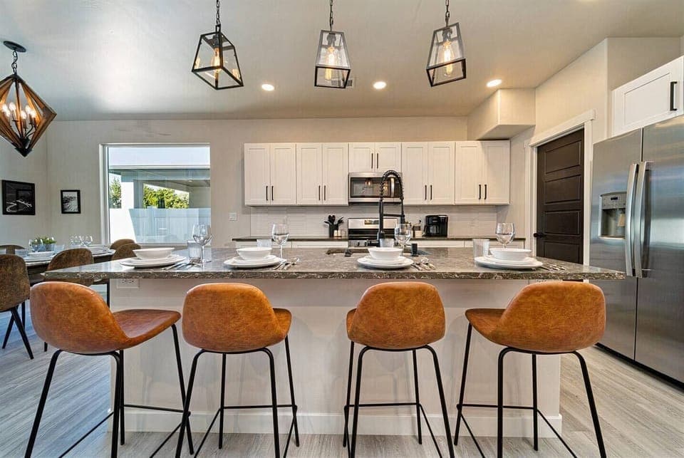 Kitchen that’s both chic and functional, with luxe granite countertops, pendant lighting, and velvet bar stools inviting you to dine in style
