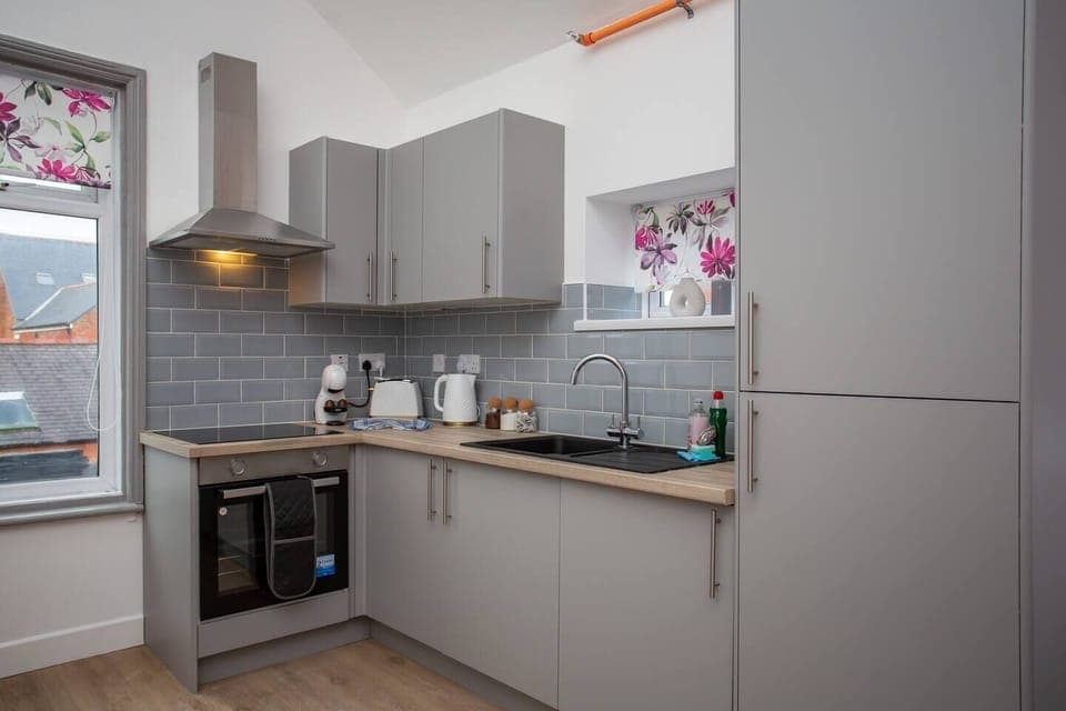 Gleaming countertops and stainless steel appliances create a chef's paradise, while a stylish heat extractor ensures a fresh and airy atmosphere as you cook up a storm.