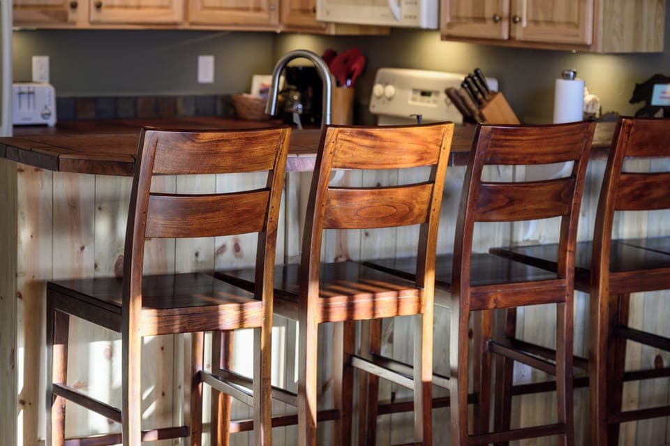 You'll love gathering at this beautiful breakfast bar with its warm wood stools and fully equipped kitchen, perfect for morning coffee and casual meals.