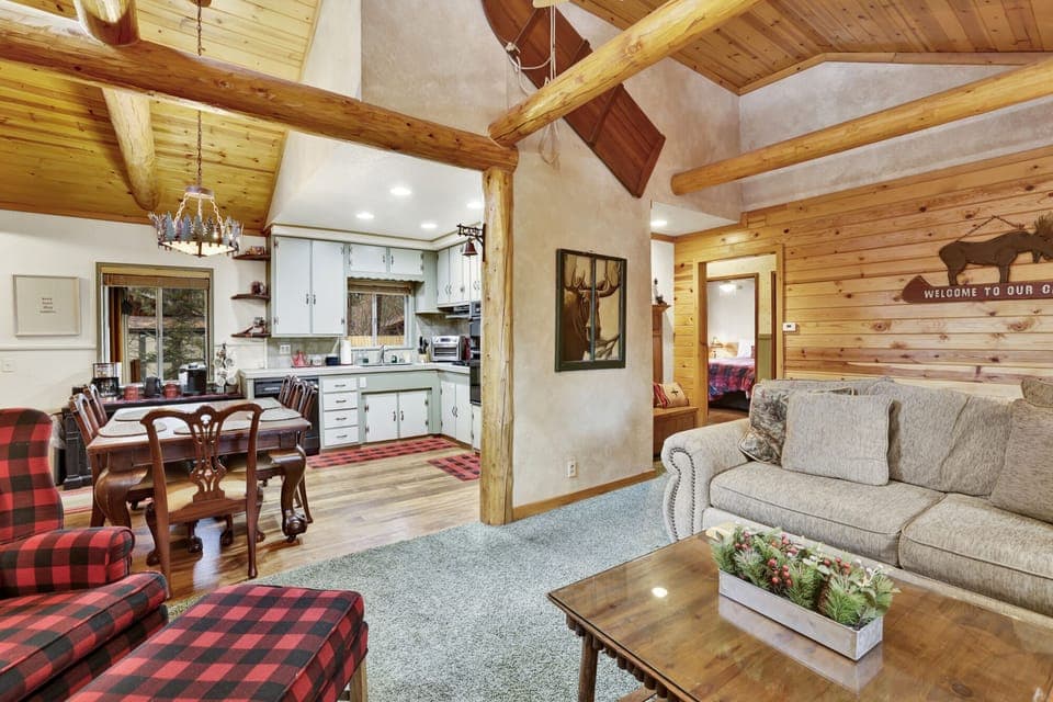 Open living room with cozy seating and glowing fireplace seamlessly connected to the modern kitchen for gatherings