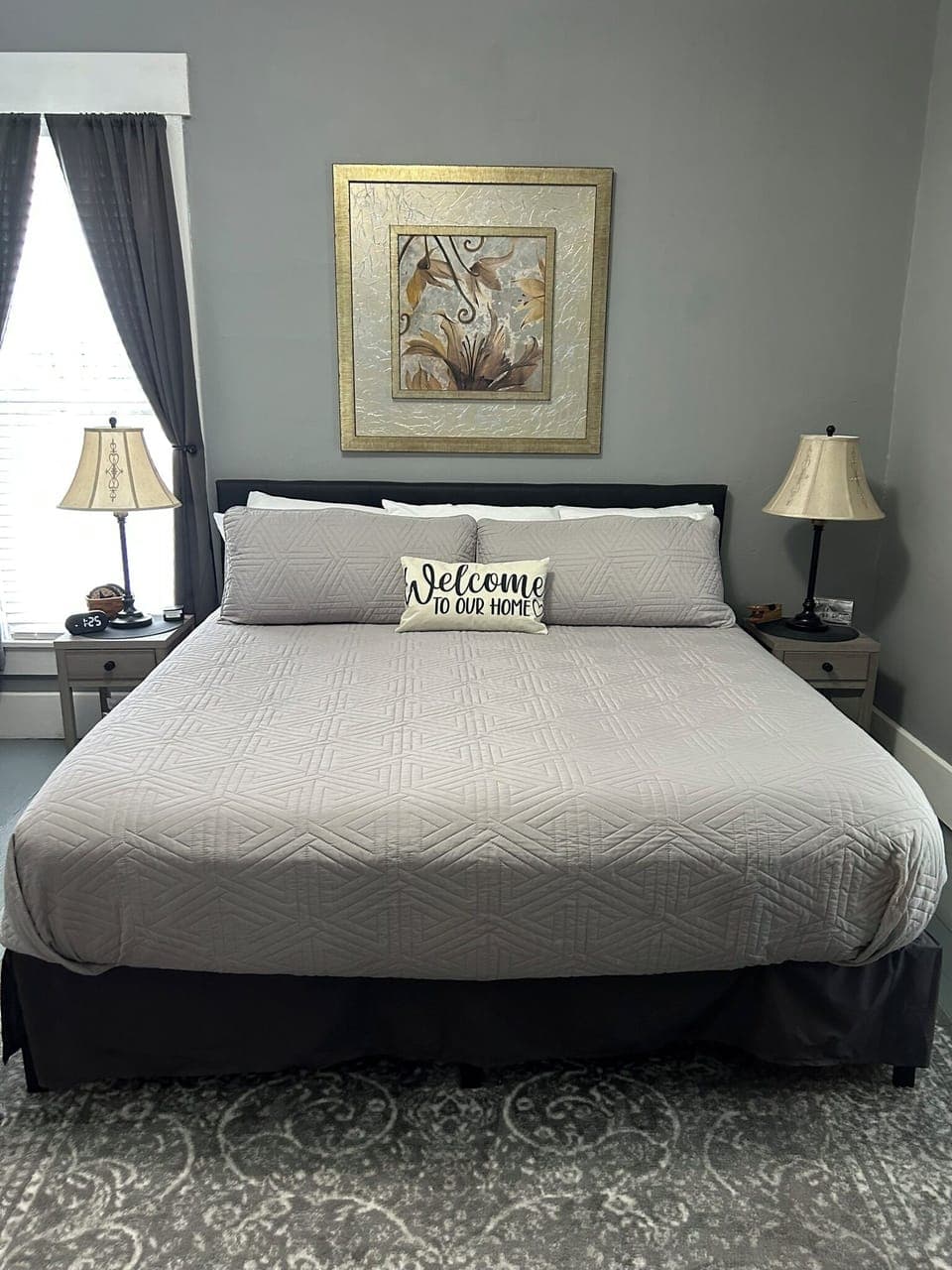 King size bed in large bedroom with custom made blinds and a ROKU TV.  