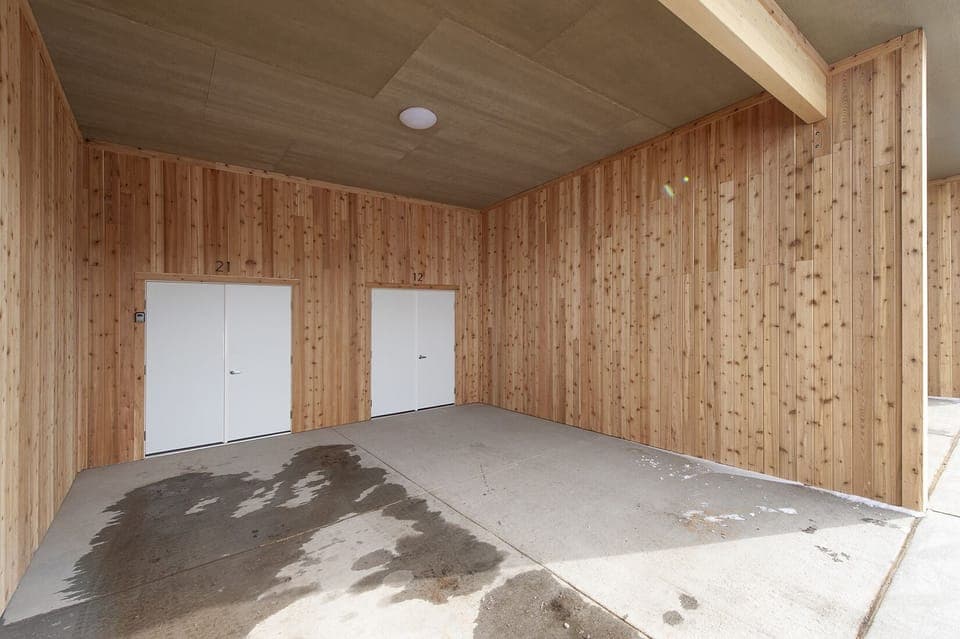 Detached covered garage with assigned parking for one vehicle and ski gear storage room.