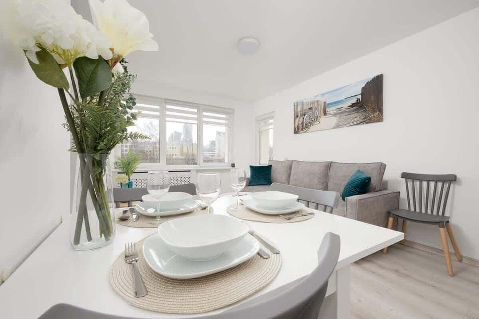 A close-up of a beautifully set dining table with fresh flowers, elegant dishware, and a bright, airy ambiance.


